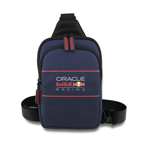 Op de foto zie je een compacte crossbodytas met schouderriem die is uitgevoerd in donkerblauwe, licht gepolsterde neopreenstof en voorzien van een groot Oracle Red Bull Racing-logo in wit en rood met subtiele rode lijnen. Hij is bedoeld om telefoon, portemonnee en sleutels veilig op te bergen en snel toegankelijk mee te nemen tijdens het reizen of bij sportieve evenementen. De tas sluit met twee soepel lopende ritssluitingen waaraan felrode siliconen trekkers zitten en de dichtgeweven stof heeft een licht waterafstotende werking. Dankzij de smalle, verstelbare draagband biedt hij draagcomfort onderweg, in de stad of bij races en is hij bijzonder geschikt voor fans en actieve gebruikers die hun spullen compact willen vervoeren. Zijn compacte formaat, waterafstotende neopreenmateriaal en stevige ritstrekkers zijn opvallende pluspunten die bescherming en gemak combineren.